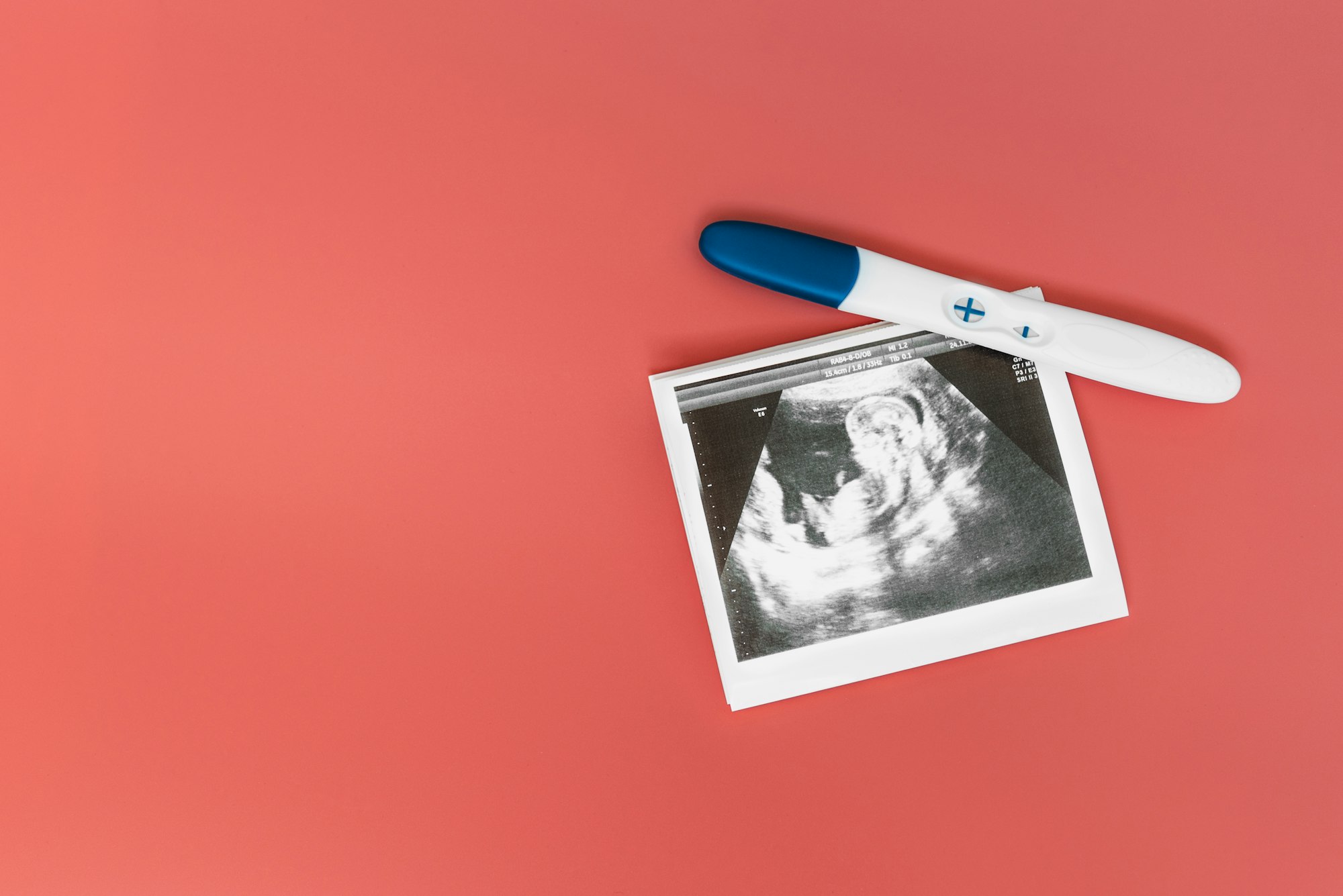 Test de grossesse positif et image d'échographie sur fond rose.