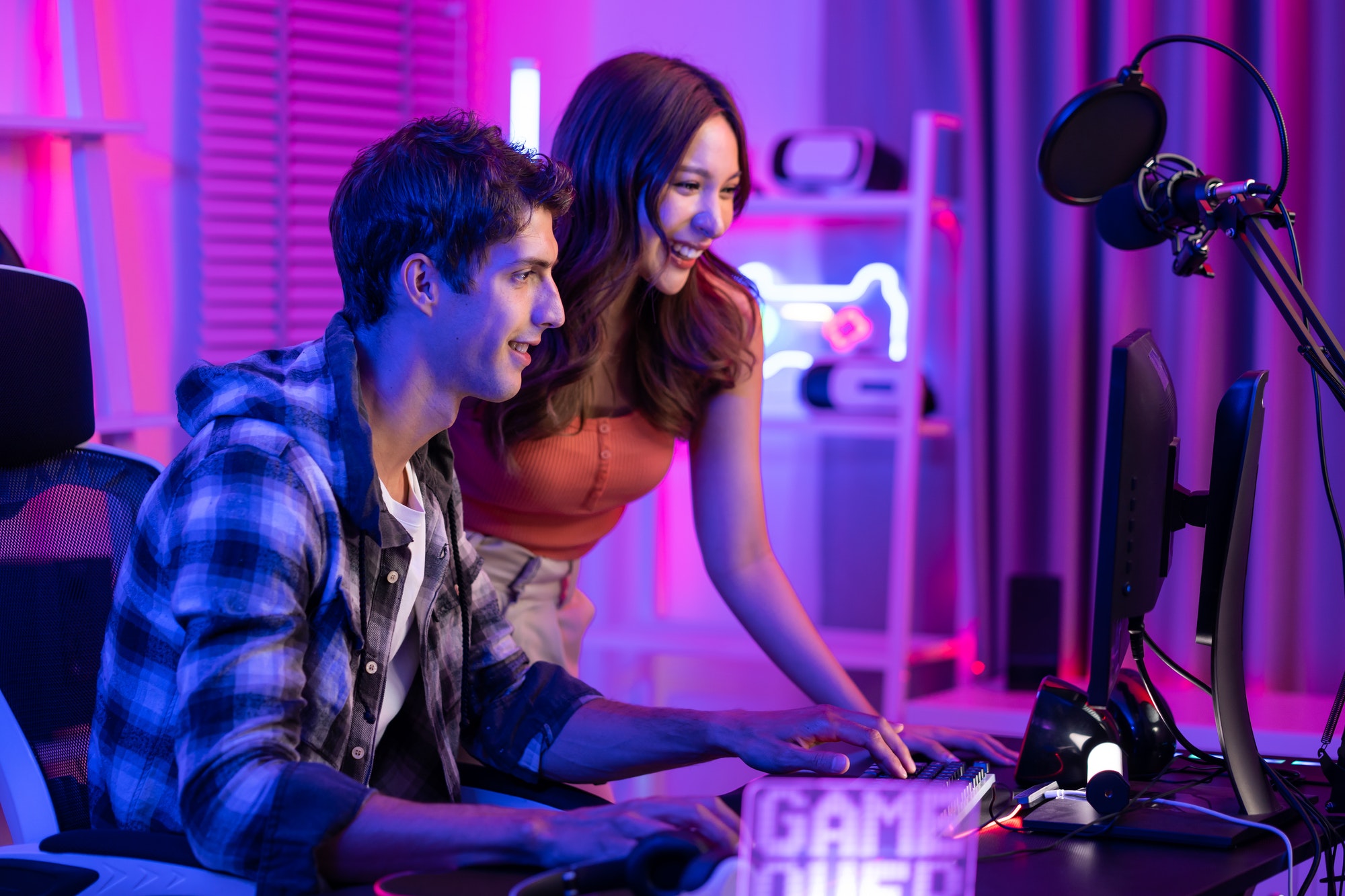 Un couple d'esport caucasien joue à un jeu vidéo en ligne sur un ordinateur.