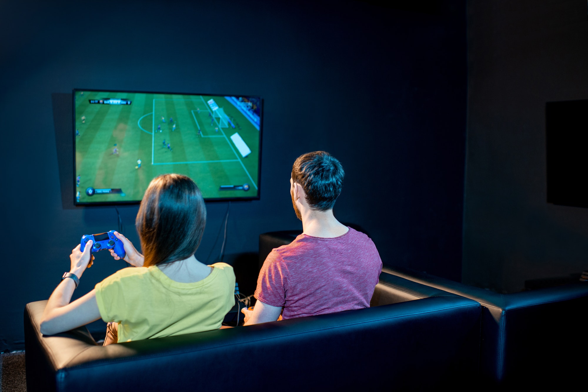 Un couple jouant à un match de football sur une console de jeu