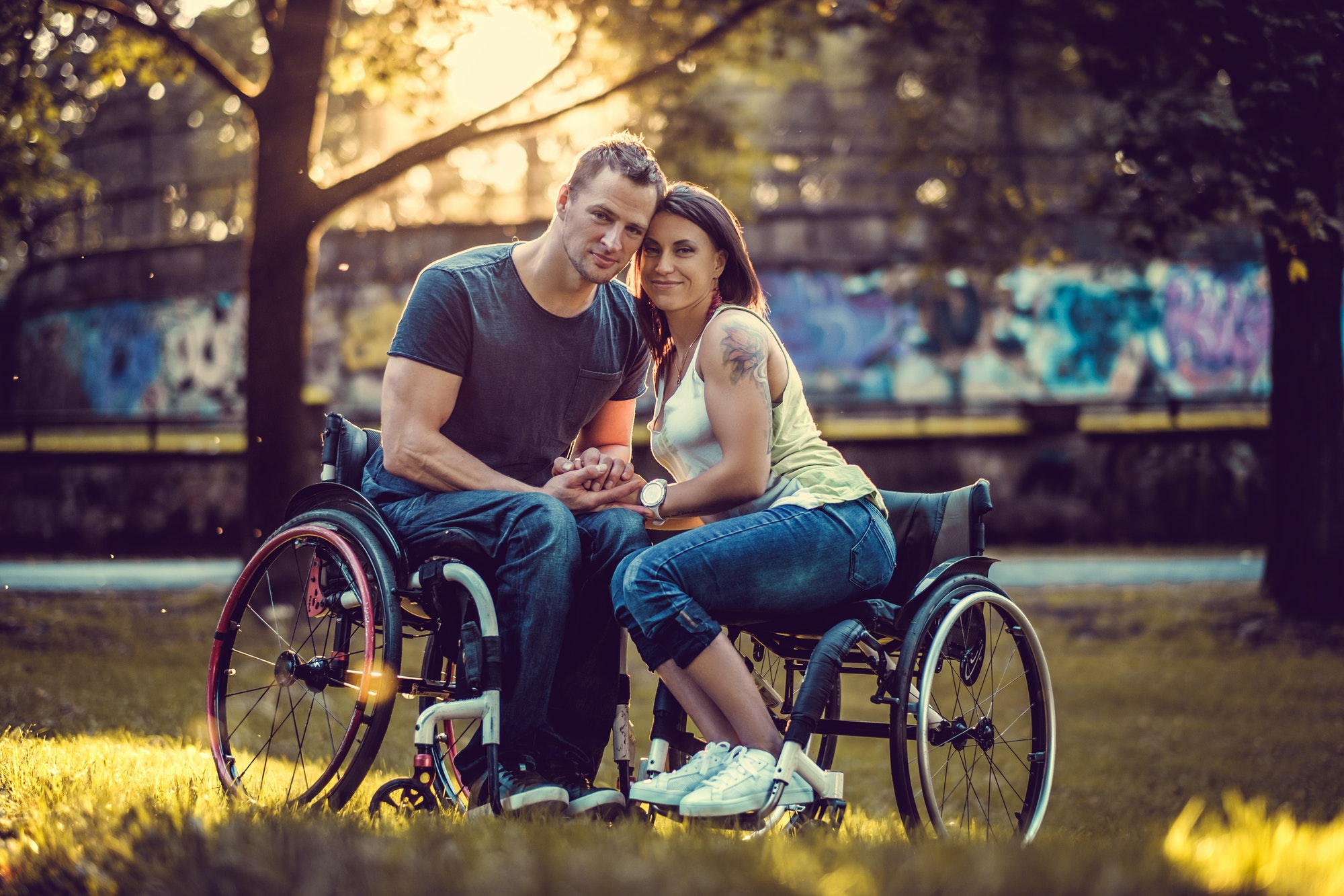Jeune couple handicapé dans deux fauteuils roulants.