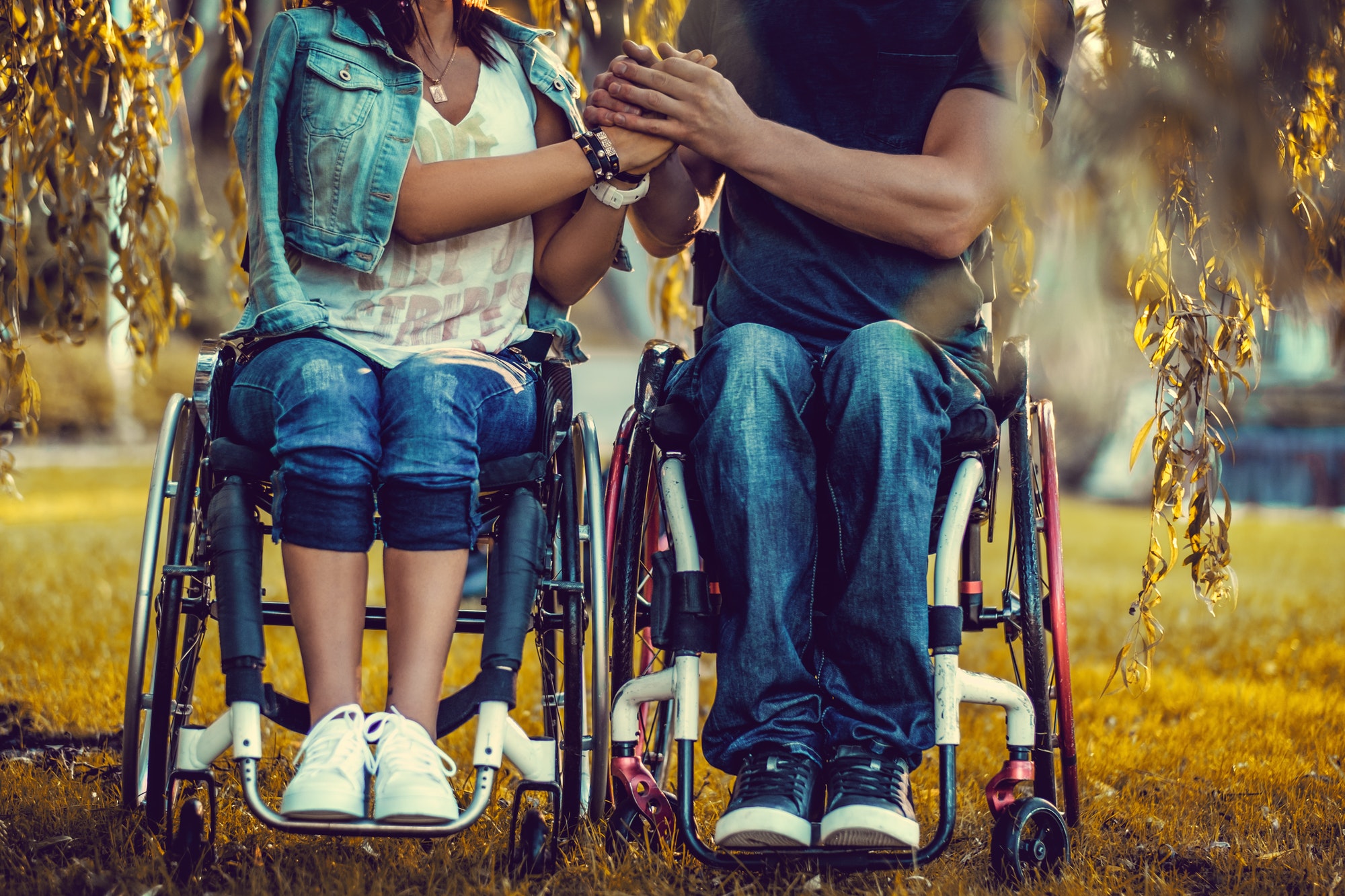 Un jeune couple de personnes handicapées dans deux fauteuils roulants.