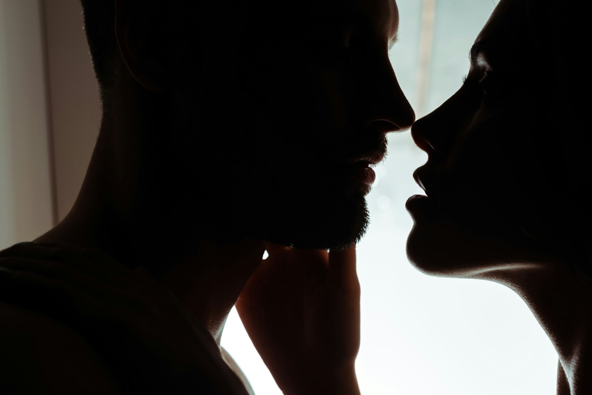 silhouettes jeune couple sexy s'embrassant passionnément