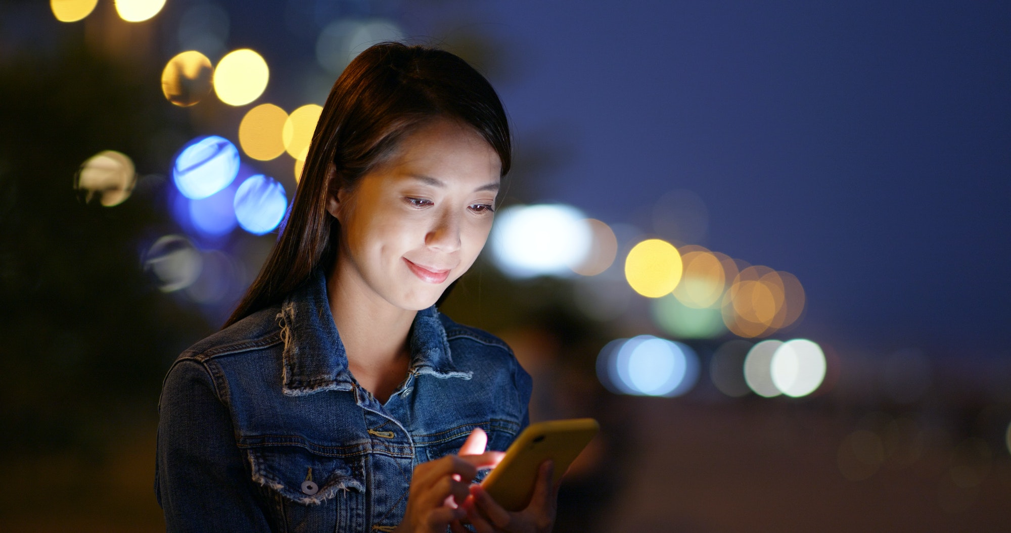 Femme regardant son téléphone portable la nuit