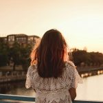 back-view-backlight-portrait-of-single-woman-on-the-bridge-over-the-river-on-sunset-city-warm-light.jpg