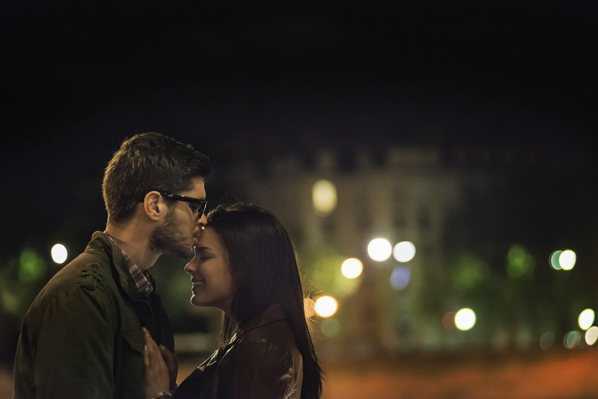 Un couple s'embrassant en ville la nuit.
