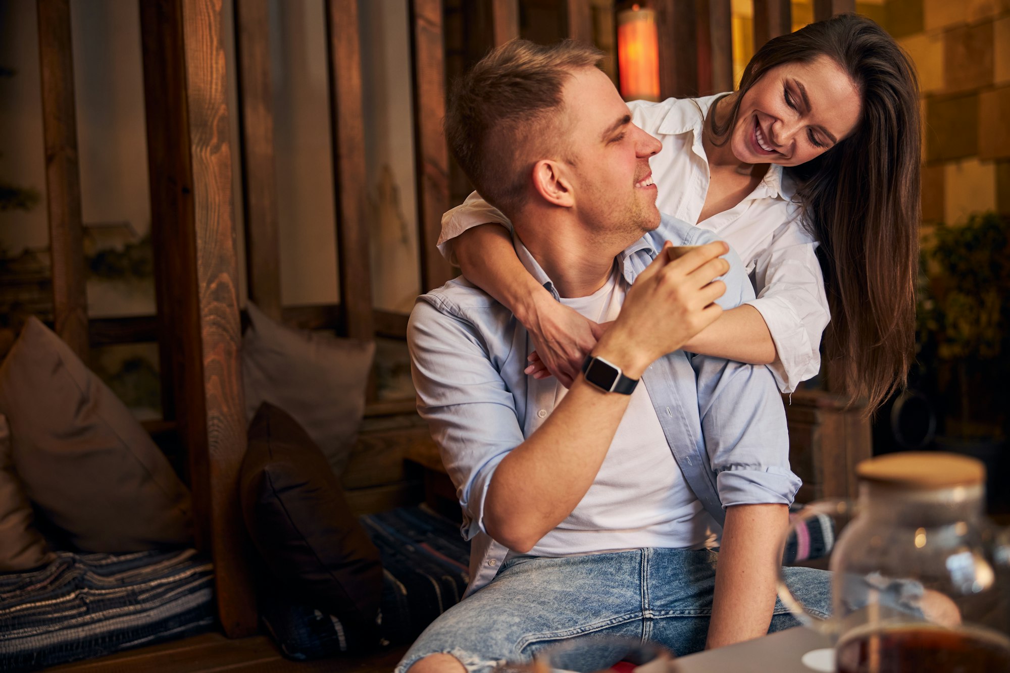 Beau jeune couple se faisant des câlins dans un café confortable