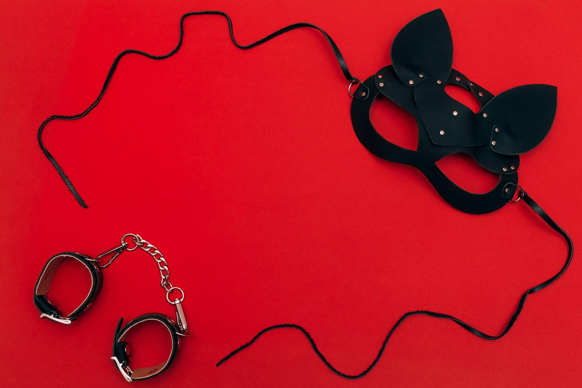 Masque de chat en cuir noir sur fond rouge Concept Saint-Valentin, communautés BDSM