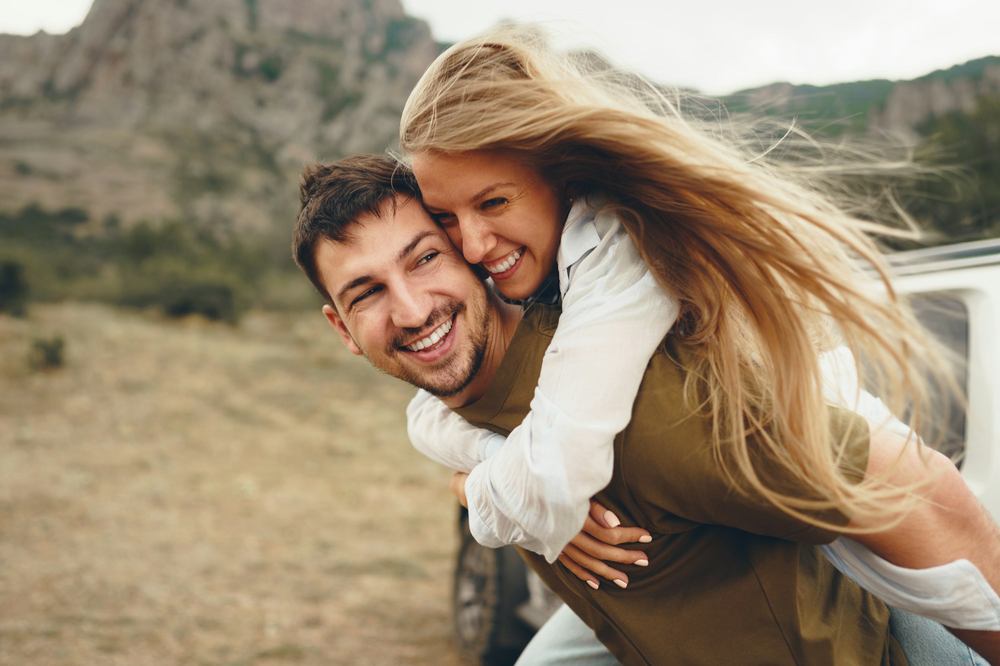 Un couple heureux et amoureux en train de randonner et de se faire des câlins dans les montagnes.
