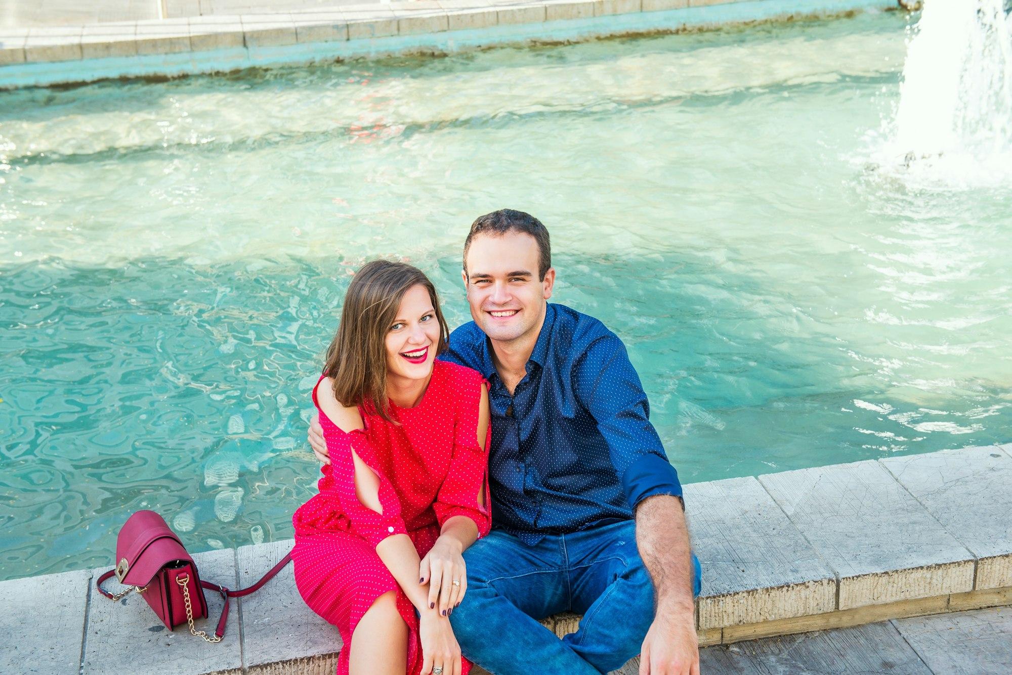 Un couple est assis près d'une fontaine et profite d'un moment de bonheur. Amour, rencontres, romance