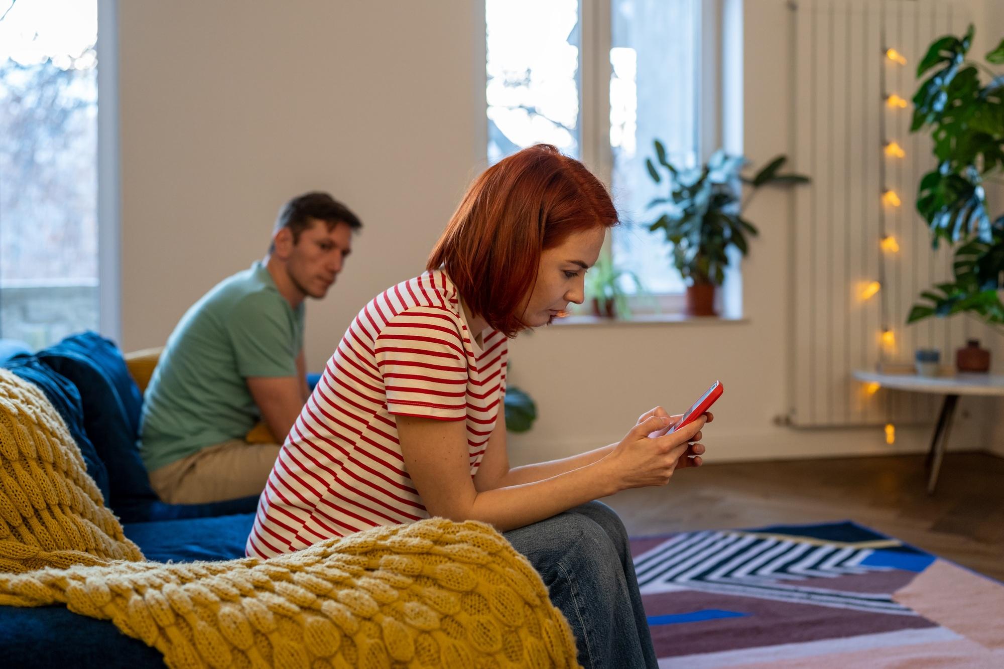 Une relation toxique. Un couple assis sur le canapé après une dispute. Une jeune fille écrit un texte de soutien sur la violence domestique