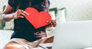 A woman chatting with her lover, holding a heart, love during COVID, long distance relationship